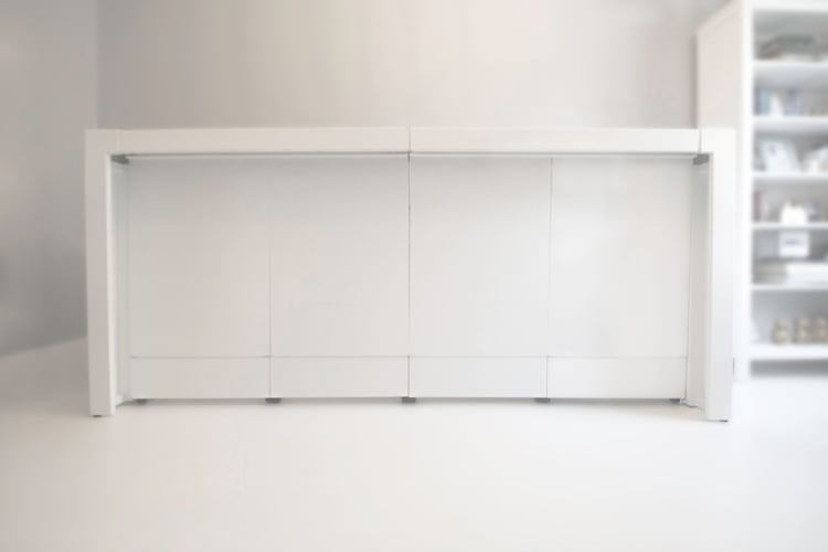 White modern storage cabinet with four panel doors in a bright, minimal room